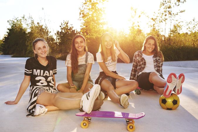 Group of female teenagers with a soccer ball and skateboard