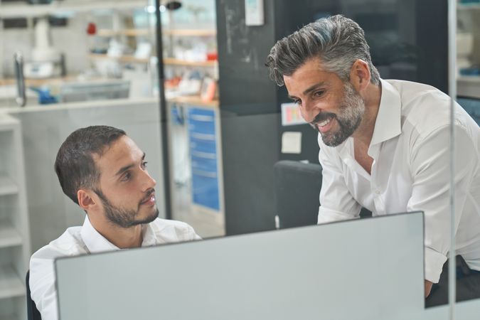 Positive workers working on computer in office