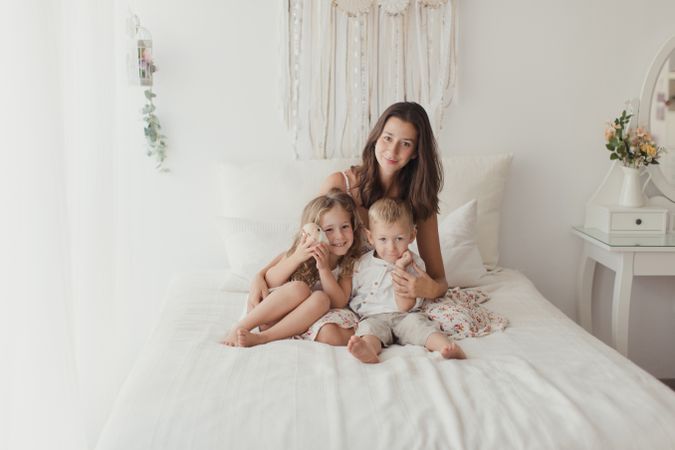 Content young mother with little kids at bedroom