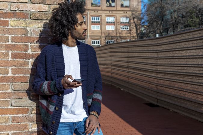 Young Black man using cellphone outdoor