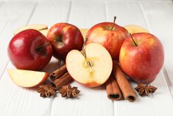 Apples on a table with anise and cinnamon sticks