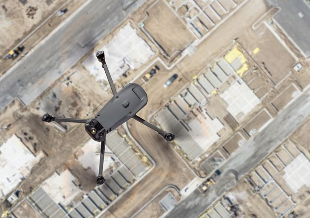 Unmanned Aircraft System Quadcopter Drone UAV In The Air Over Construction Site.