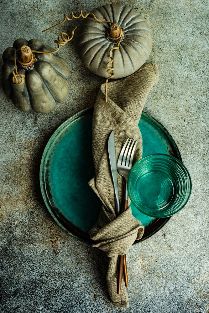 Autumnal table setting of decorative pumpkins and teal plate