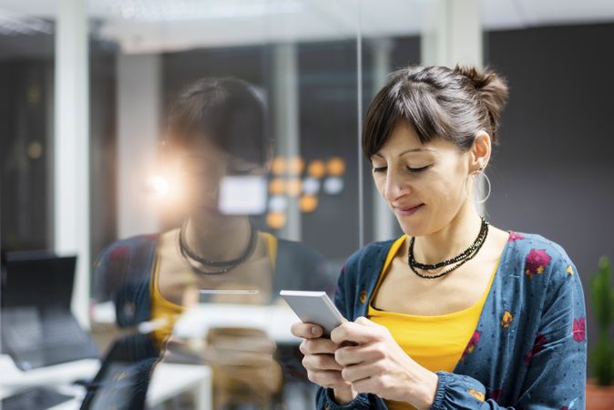 Woman browsing smartphone in office
