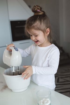 Young girl making a cake in the kitchen
