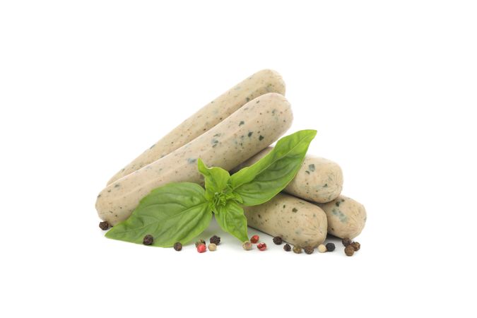 Light colored sausages on blank background with herbs