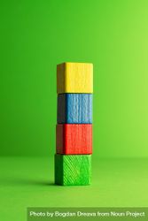 Colorful wooden blocks stacked neatly over green background 0LYqe5