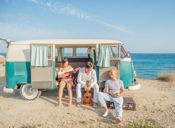 family having fun with musical instruments near car