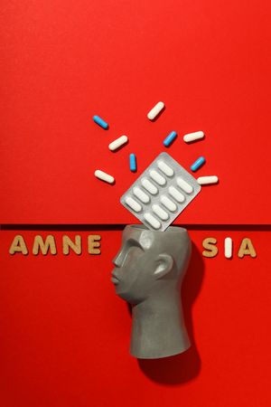 Vertical composition of model of bust with pills and the words “Amnesia” copy space