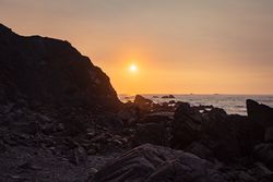 Close up of rocky tide pools near beach at sunset