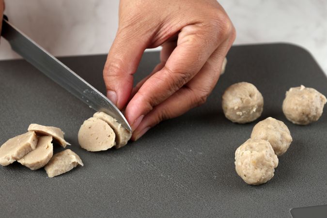 Female Hand Slicing Bakso or Beef Meatballs