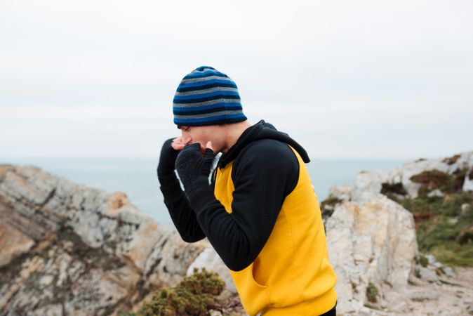 Kickboxer training on cliff near sea