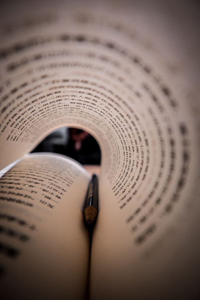 Pen in a book with turned page like tunnel