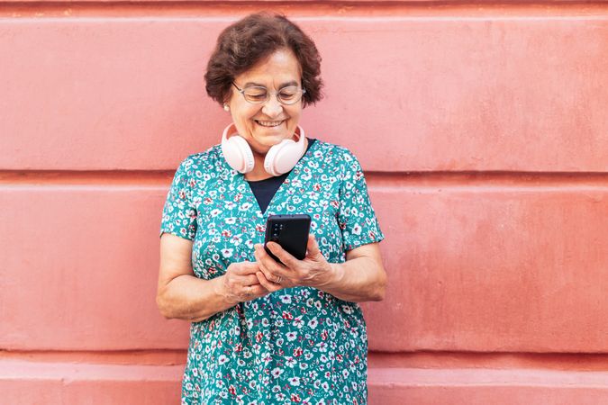 Smiling older woman using smartphone outdoors