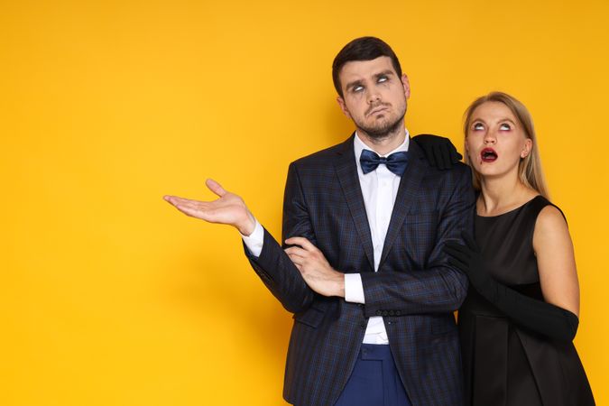 A couple in Halloween costumes on a yellow background