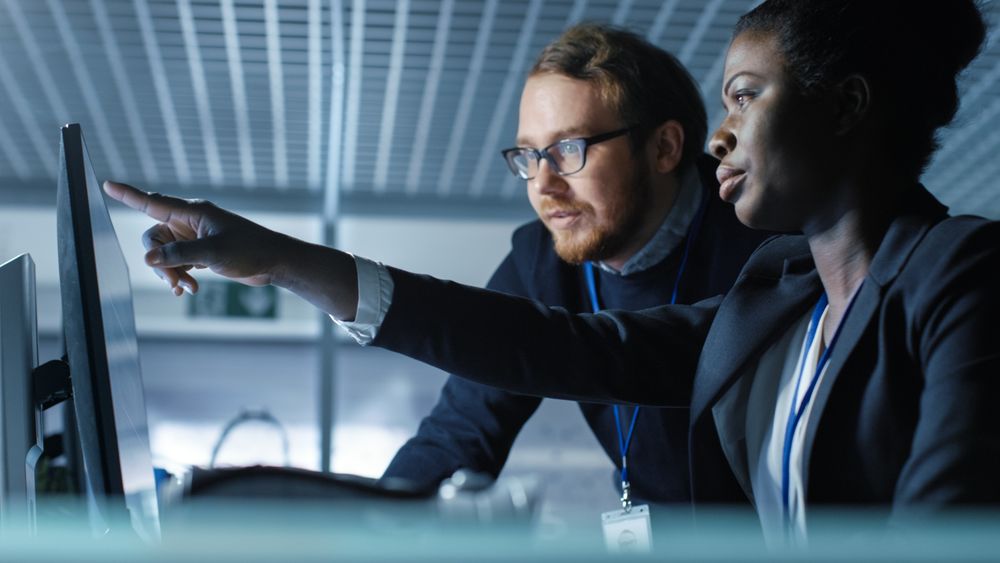 Female Scientist Works on a Computer and Having Discussion with Male Colleague.