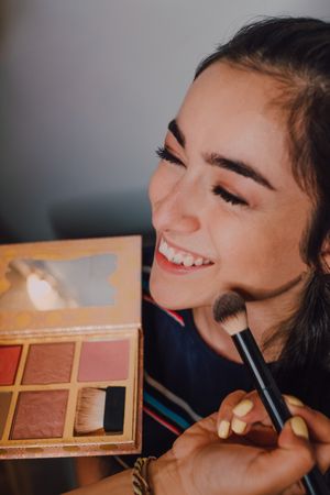 young female getting makeup in salon