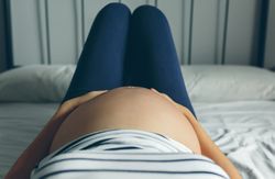 Pregnant lying touching her belly
