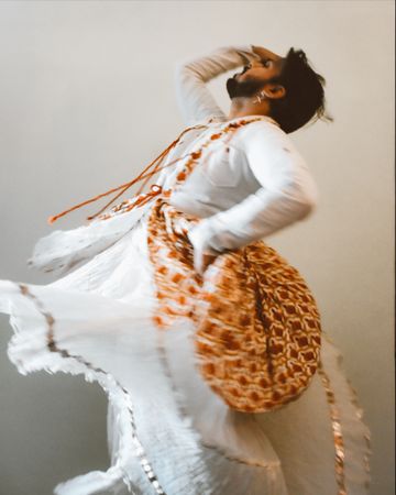 Indian man in kathak dress dancing for Tulsi Vivah