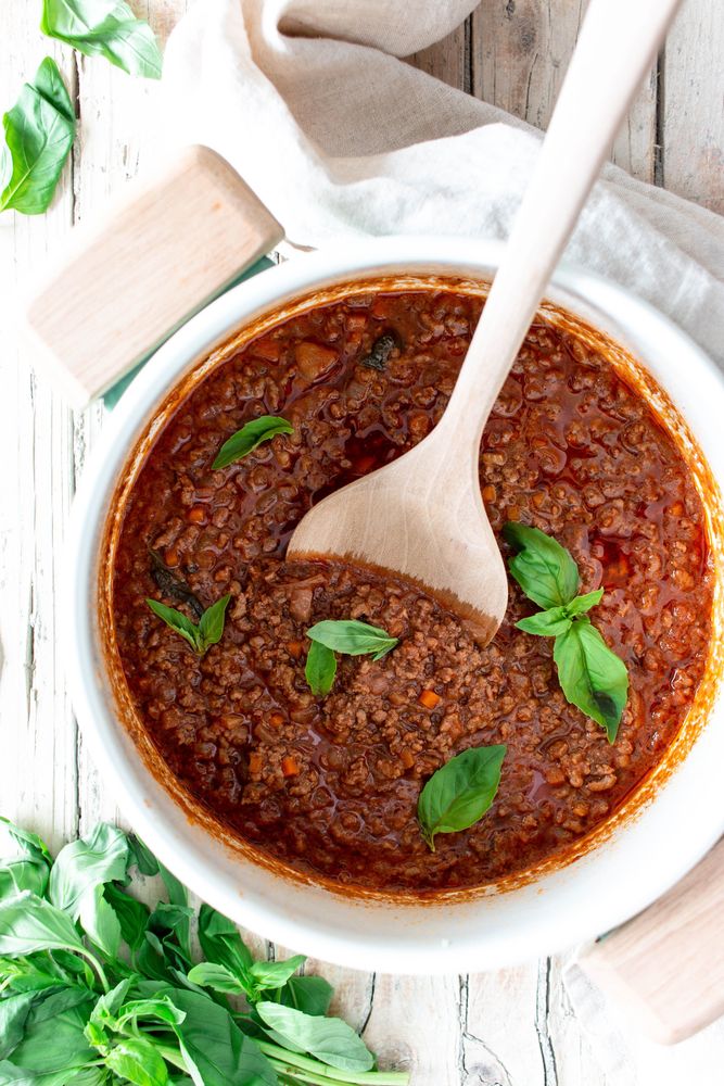 Pan with ragout Bolognese on wooden table