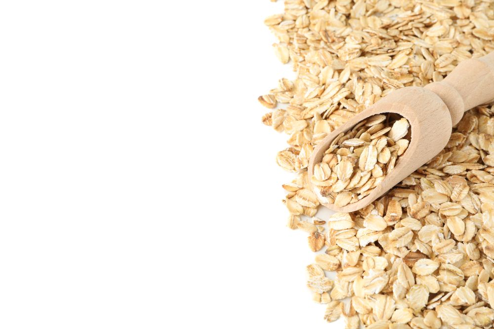 Scoop and oatmeal flakes frame isolated on plain background