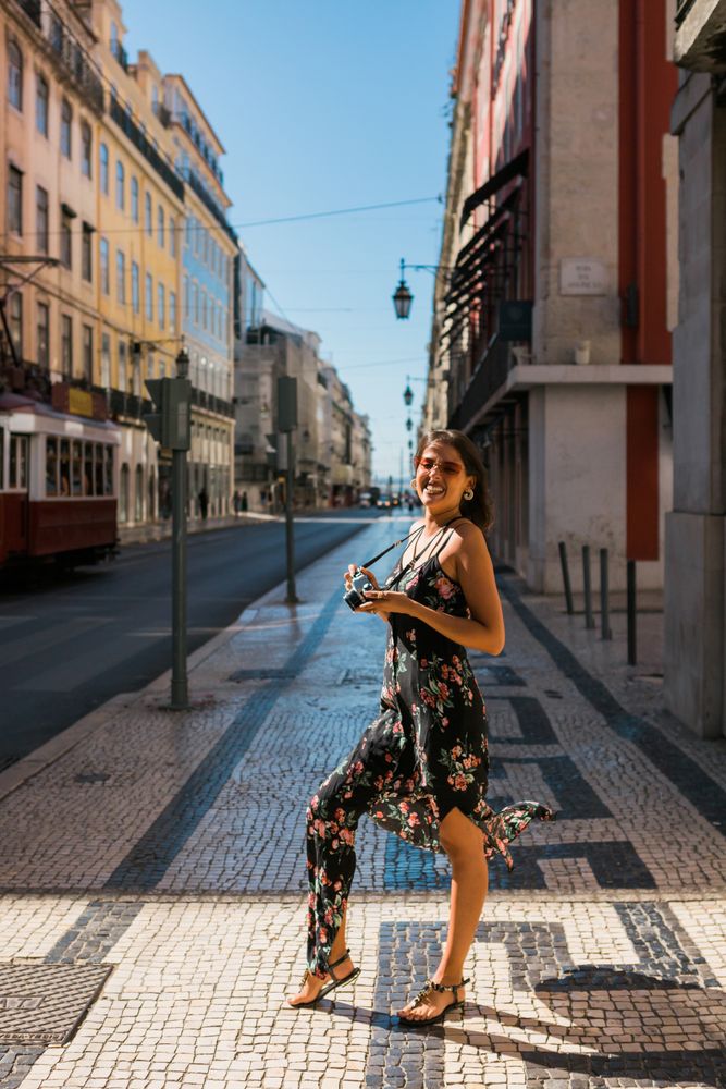 Woman holding a camera while standing on street