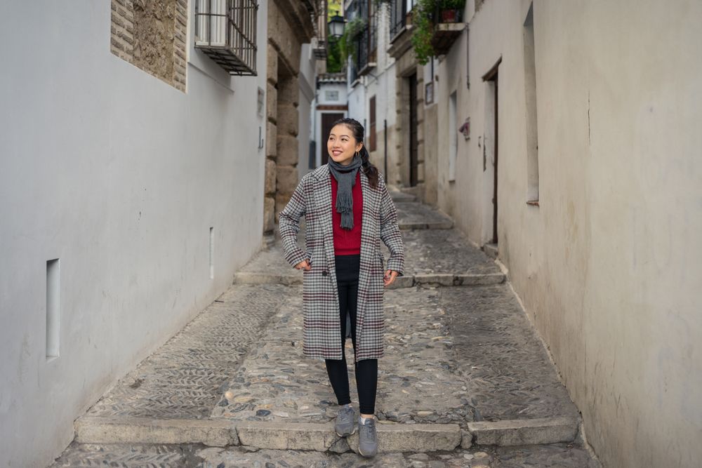 Joyful female tourist in casual wear amid city street