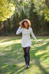 Smiling woman walking through park on sunny day