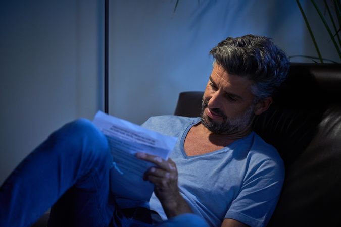 Concentrated employee writing notes in dark room