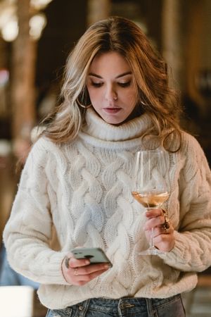 Stylish woman drinking wine in bar