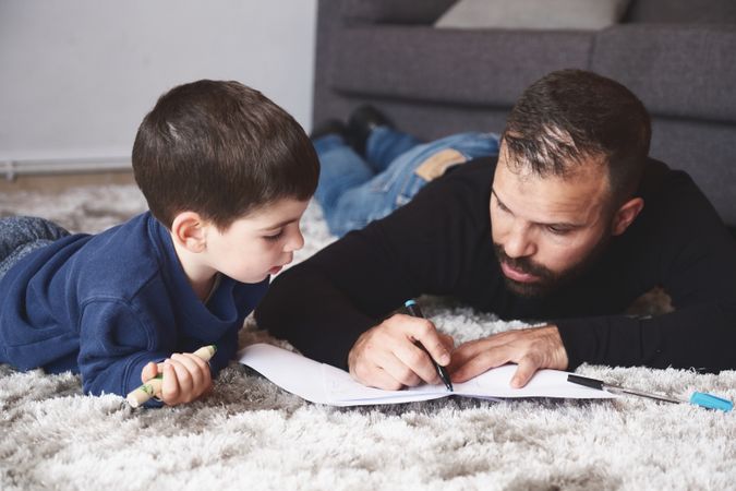 Father and son drawing on floor