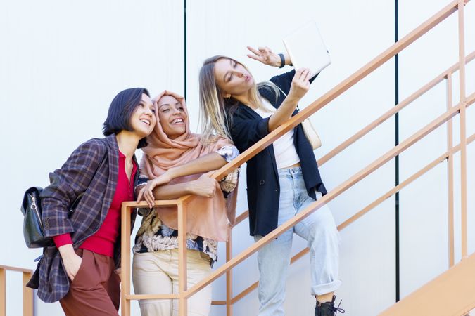 Three happy women taking selfie on digital tablet