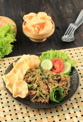 Plate of lotek, Sudanese vegetable salad with peanut dressing on placemat