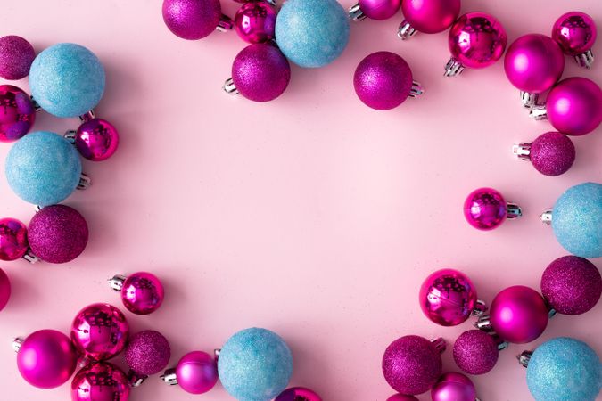 Pink and blue festive baubles bordering pink background
