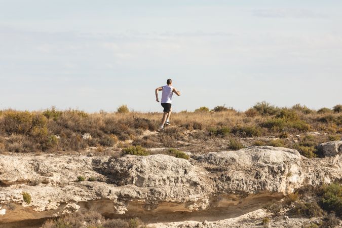 Man in the distance running in rugged terrain