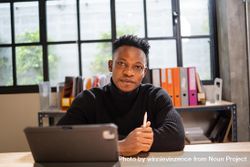 Serious Black male creative smiling and sitting at laptop in relaxed modern office 0PYve5