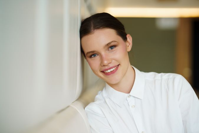 smiling woman in elegant white clothes in a cafeteria