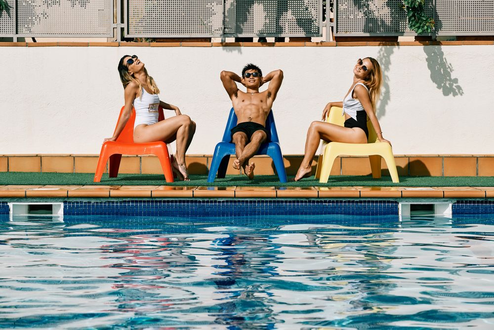 a group of young models by the pool with sunglasses