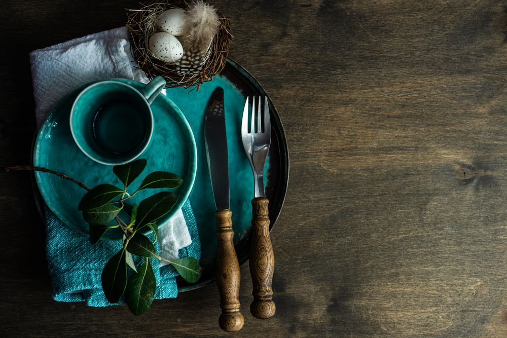 Top view of Easter table setting with teal plates and blue decorative eggs