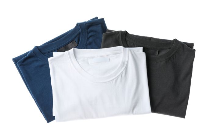 Folded multicolored t-shirts isolated on plain background, space for text