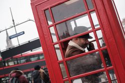 Adult man using telephone box