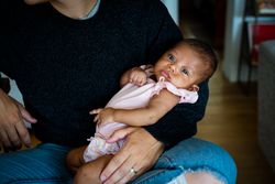 Close up of baby being held in mother’s arms