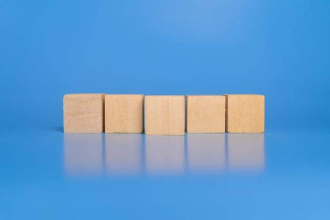 an empty wooden blocks with closer wooden blocks in the center isolated on blue background