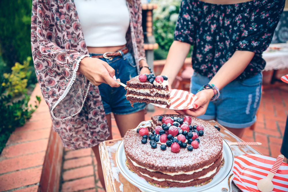 Woman serving chocolate cake in a summer party
