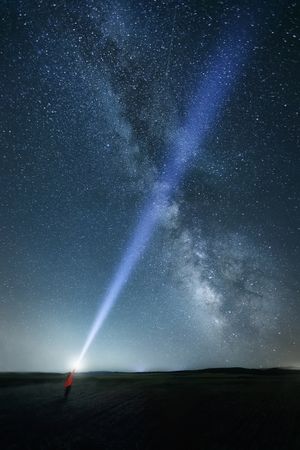 Starry sky and person with ray of light