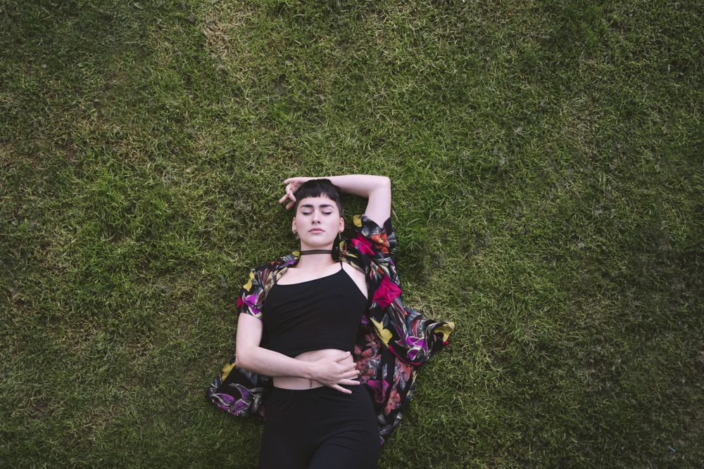 Woman in colored shirt lying on grass