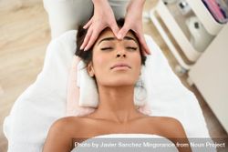 Woman receiving a facial massage from a aesthetician 4mq2d4