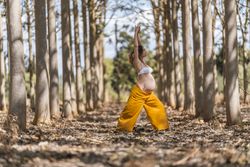 Concentrated adult expectant mother practicing yoga in park