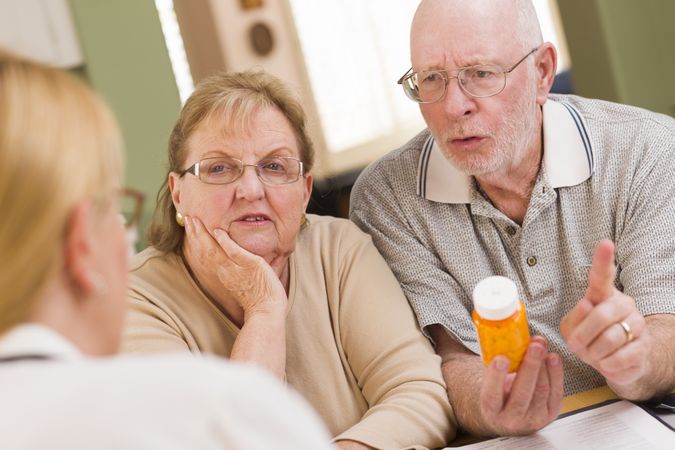 Doctor or Nurse Explaining Prescription Medicine to Older Couple