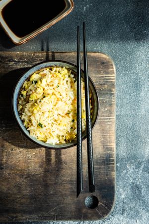 Chinese rice in bowl on wooden board